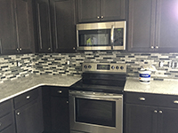 dark kitchen cabinets with gray mosaic backspash