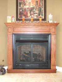 oak wood mantel and ventless fireplace surround in a basement